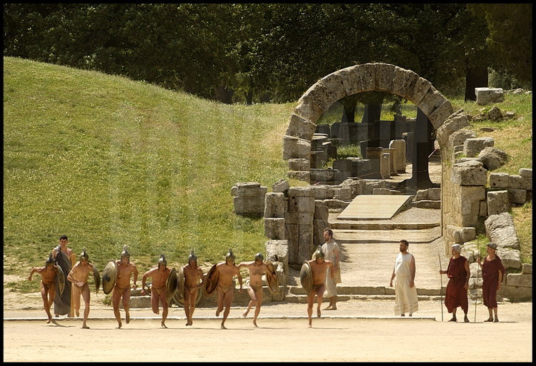 Two-stadiums long (2x192m), the hoplites armed race (hiplitodromos) was open to athletes from all different sports.  The runners at the start of the race surrounded by hellanodices Jean-Claude Perrin and Harald Schmid on the left, the Mastigophore and hellanodices Georges Ballery and Philippe de Carbonière on the right.